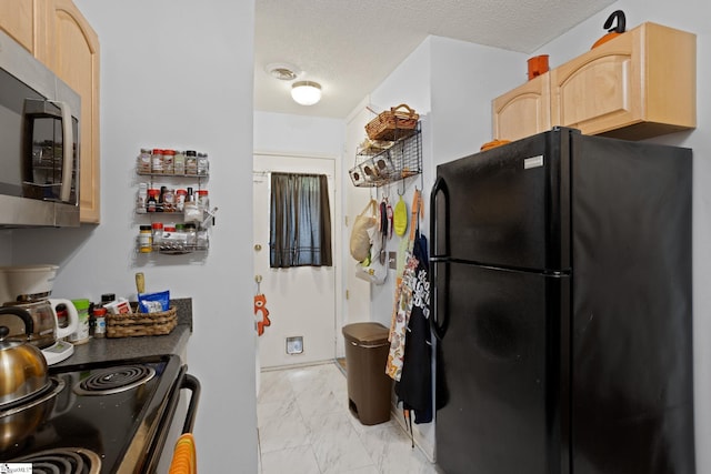 kitchen featuring appliances with stainless steel finishes, light brown cabinetry, light marble finish flooring, and a textured ceiling