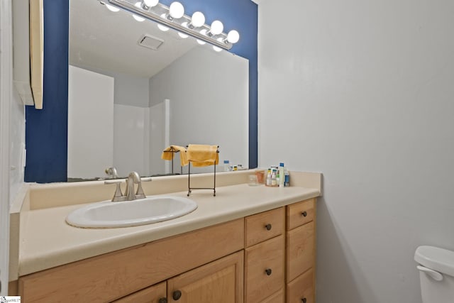 bathroom featuring toilet and vanity