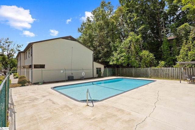 view of swimming pool featuring a patio area, fence, and central AC