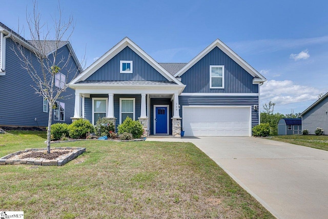 craftsman inspired home with board and batten siding, a garage, a front yard, driveway, and stone siding