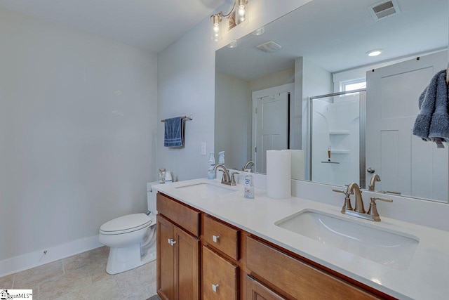 bathroom with baseboards, a stall shower, toilet, double vanity, and tile patterned floors