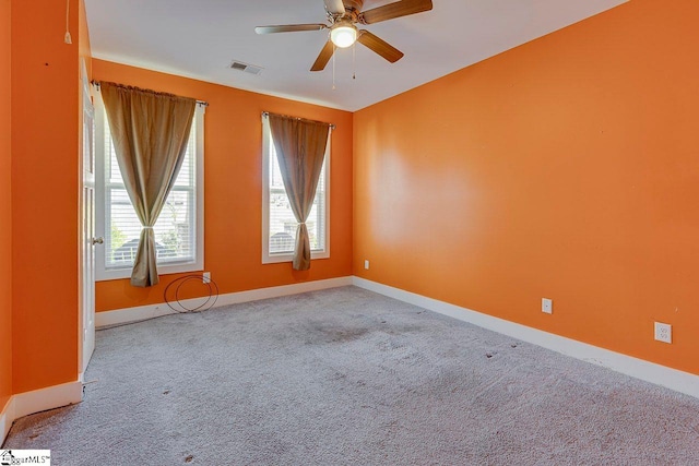 spare room featuring a ceiling fan, carpet floors, and baseboards