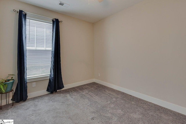 carpeted spare room featuring baseboards and a ceiling fan