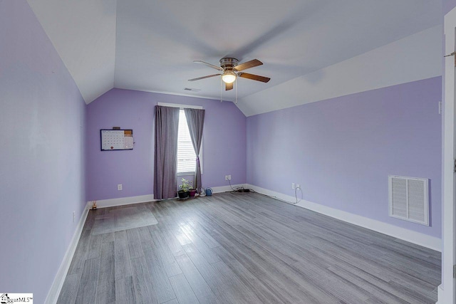 bonus room with a ceiling fan, lofted ceiling, wood finished floors, and baseboards