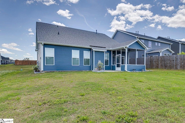 rear view of property featuring a sunroom and a shingled roof