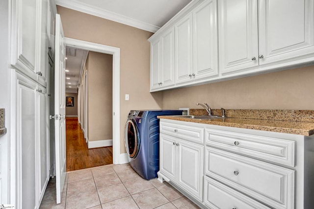 clothes washing area featuring cabinet space, ornamental molding, light tile patterned floors, baseboards, and washer and dryer