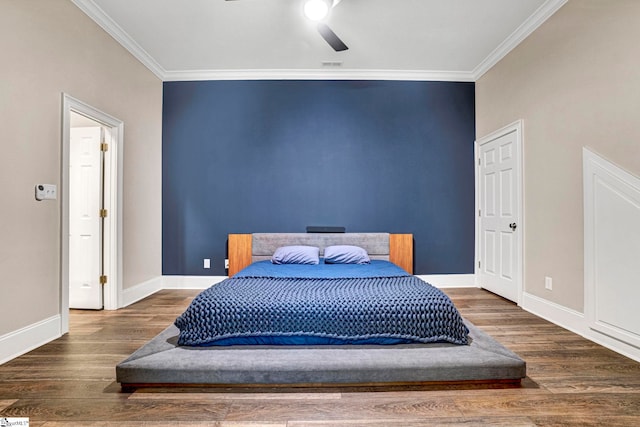 bedroom featuring crown molding, wood finished floors, baseboards, and ceiling fan