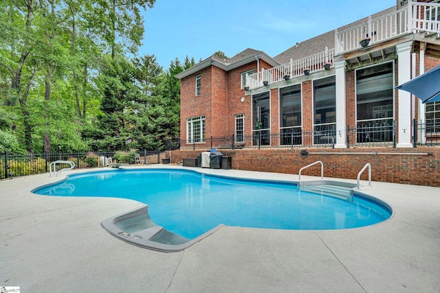 view of swimming pool featuring a patio and fence