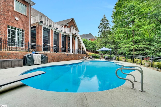 view of pool featuring fence, a grill, a patio area, and a diving board