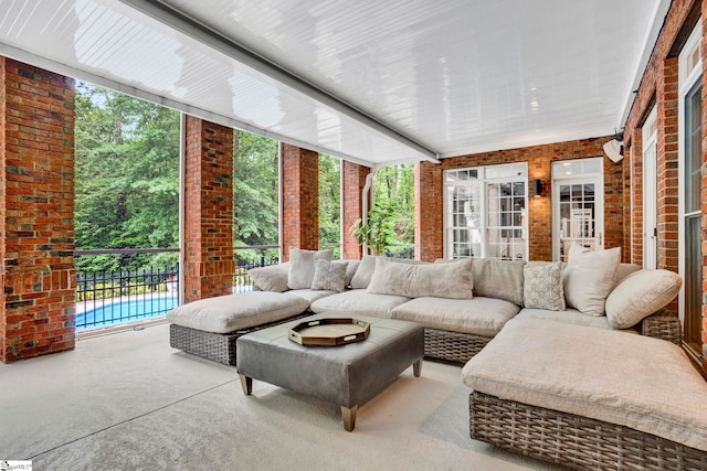 sunroom / solarium featuring brick wall and outdoor lounge area