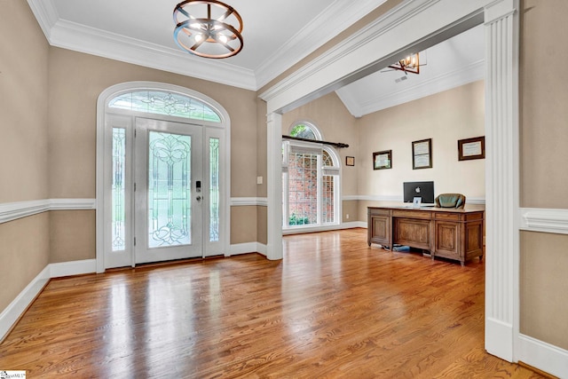 foyer entrance with light wood finished floors, crown molding, and baseboards