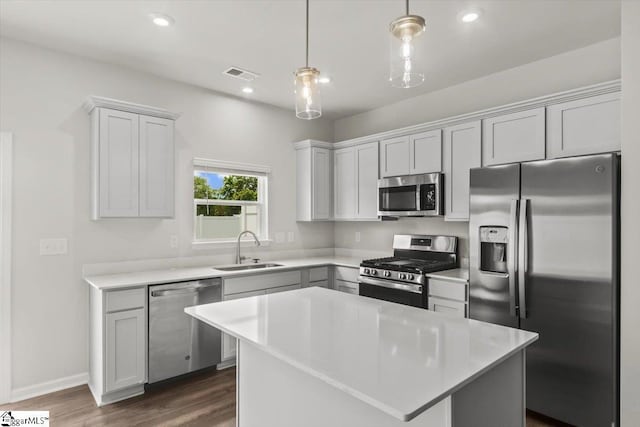 102 Randwick Ln, Greer, SC 29651 - kitchen featuring appliances with stainless steel finishes, a sink, light countertops, decorative light fixtures, and dark wood finished floors