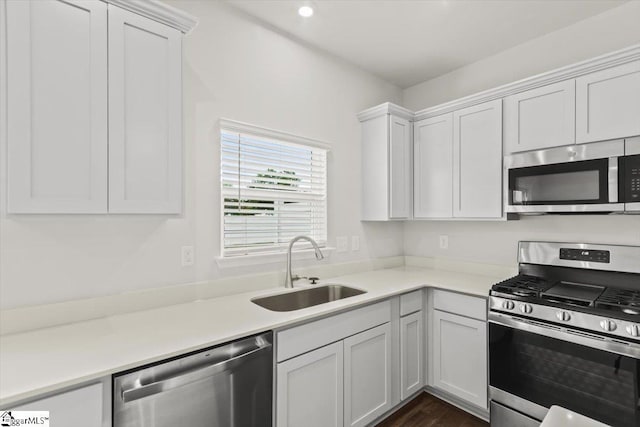 102 Randwick Ln, Greer, SC 29651 - kitchen with stainless steel appliances, a sink, light countertops, white cabinets, and dark wood-style flooring