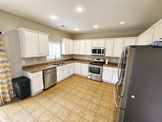 kitchen featuring appliances with stainless steel finishes, a sink, white cabinets, and recessed lighting