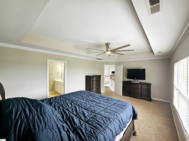 bedroom with a raised ceiling, light carpet, baseboards, ensuite bathroom, and ornamental molding