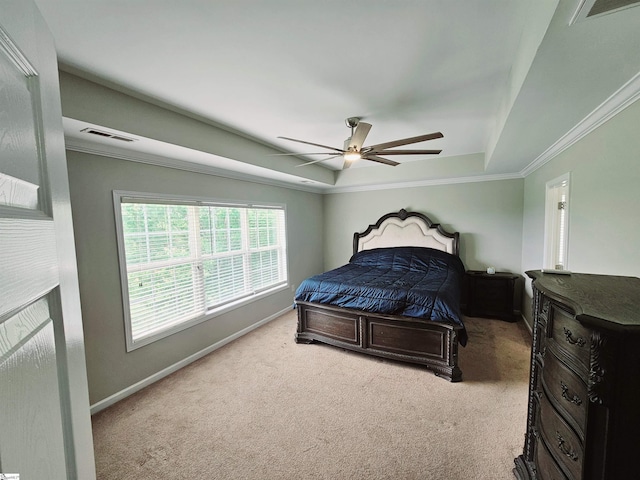 carpeted bedroom featuring a tray ceiling, baseboards, ceiling fan, and ornamental molding