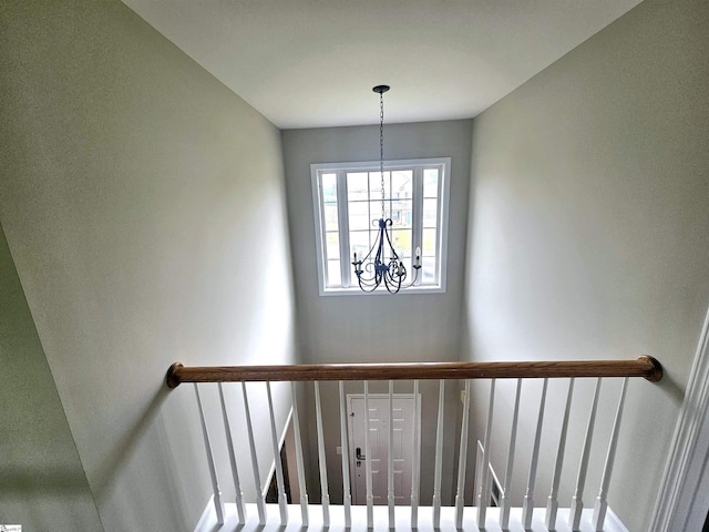staircase featuring a chandelier