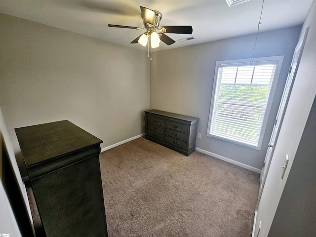 unfurnished bedroom featuring attic access, carpet flooring, baseboards, and ceiling fan