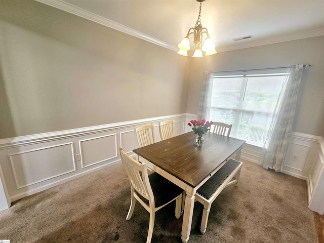 carpeted dining area featuring a decorative wall, a chandelier, a wainscoted wall, and crown molding