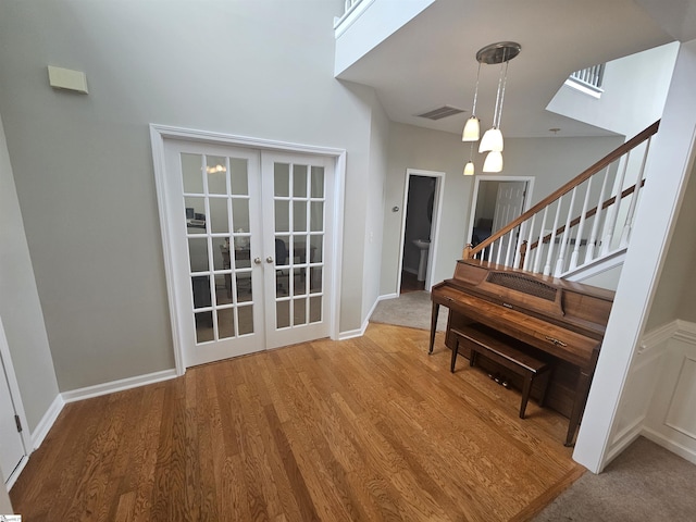 entryway featuring wood finished floors, stairway, french doors, and baseboards