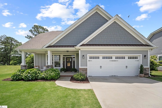 craftsman-style house featuring a standing seam roof, a front yard, concrete driveway, a garage, and metal roof