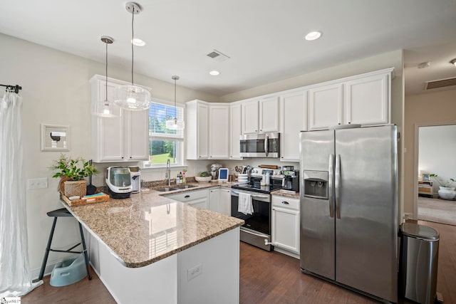 kitchen featuring stainless steel appliances, a sink, a peninsula, white cabinets, and recessed lighting