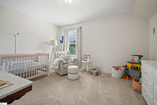 bedroom featuring a crib, carpet, baseboards, and lofted ceiling
