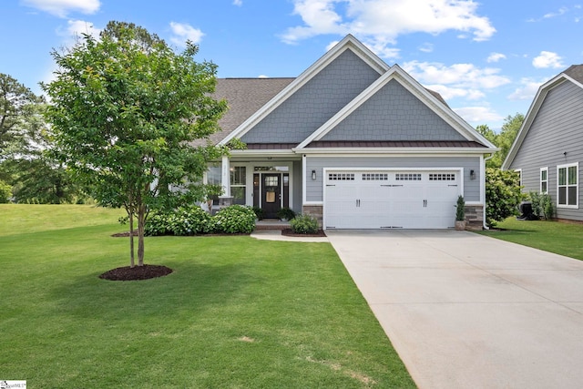 craftsman-style house with a garage, a front lawn, concrete driveway, a standing seam roof, and stone siding