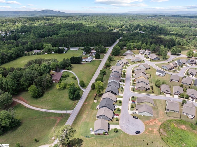 view of property location with a forest and nearby suburban area
