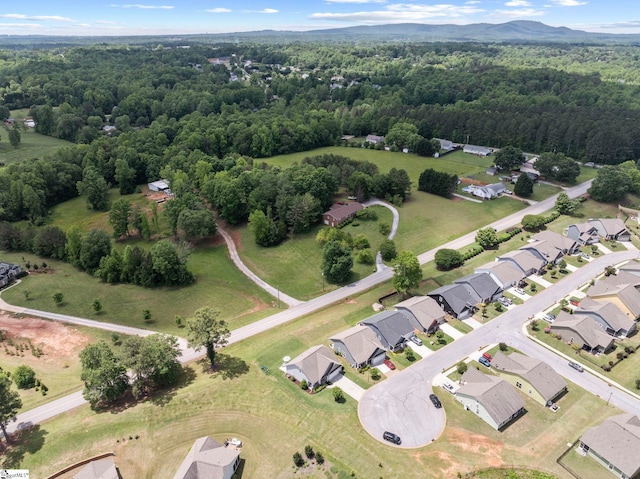 view of property location with a forest and nearby suburban area