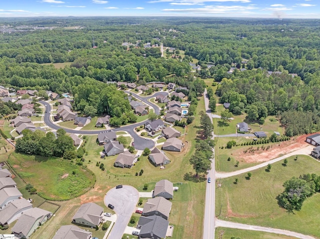 view of property location with a forest and nearby suburban area
