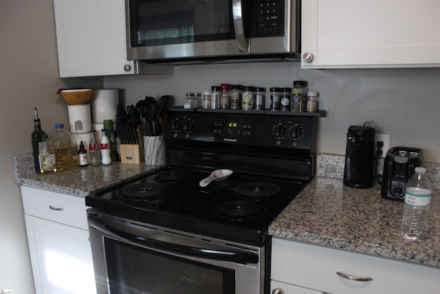 305 N Owens St, Clinton, SC 29325 - kitchen featuring electric range oven, stainless steel microwave, white cabinetry, and light stone countertops