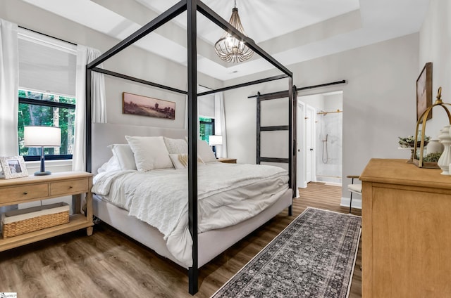 203 N Hogan Dr, Westminster, SC 29693 - bedroom with a barn door, wood finished floors, a chandelier, and ensuite bath