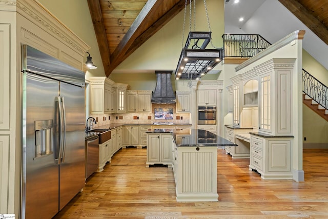 160 Mountain Brook Trl, Greenville, SC 29609 - kitchen featuring stainless steel appliances, cream cabinetry, premium range hood, a kitchen island, and high vaulted ceiling