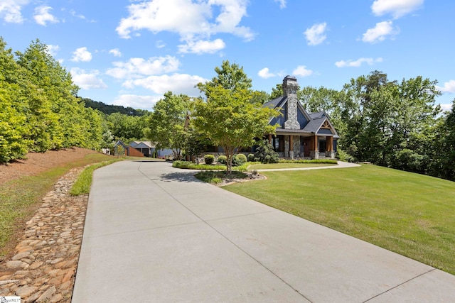 160 Mountain Brook Trl, Greenville, SC 29609 - obstructed view of property featuring a front lawn, a chimney, driveway, and covered porch