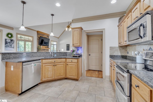 kitchen featuring stainless steel appliances, a sink, crown molding, tasteful backsplash, and dark stone counters