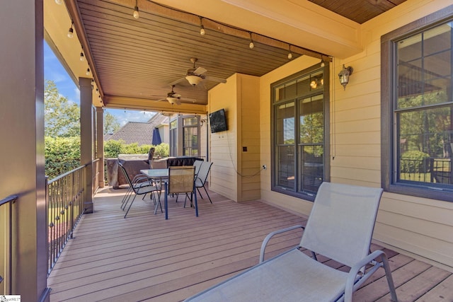 wooden deck with a ceiling fan and outdoor dining space