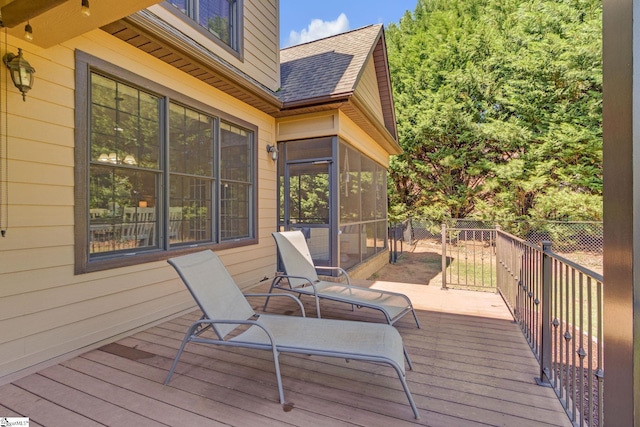 deck featuring a sunroom and fence