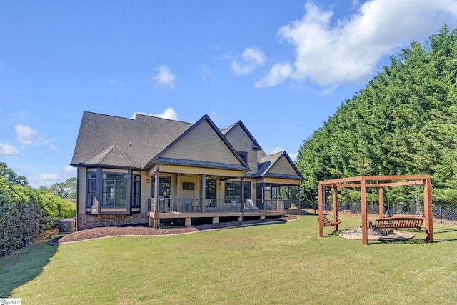 rear view of property featuring ceiling fan and a shingled roof