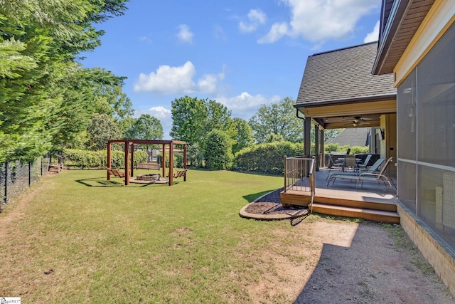 view of yard featuring a deck and a ceiling fan