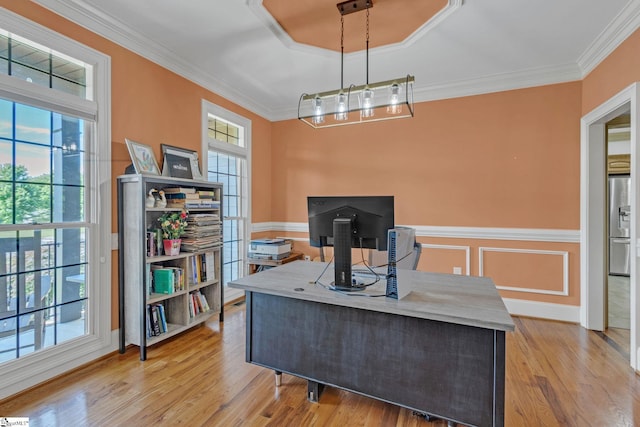 home office featuring healthy amount of natural light, crown molding, light wood-type flooring, and wainscoting