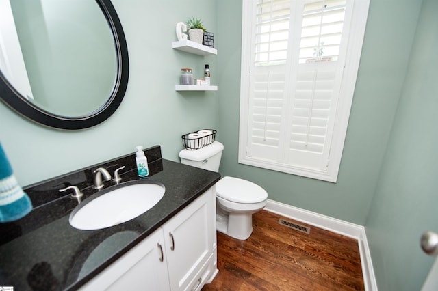 bathroom with toilet, wood finished floors, and vanity