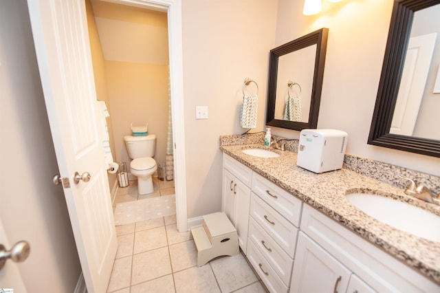 bathroom with tile patterned flooring, toilet, and double vanity