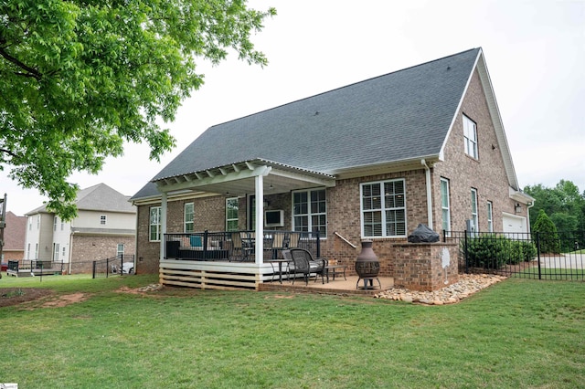 back of property with brick siding, a wooden deck, roof with shingles, and a patio area