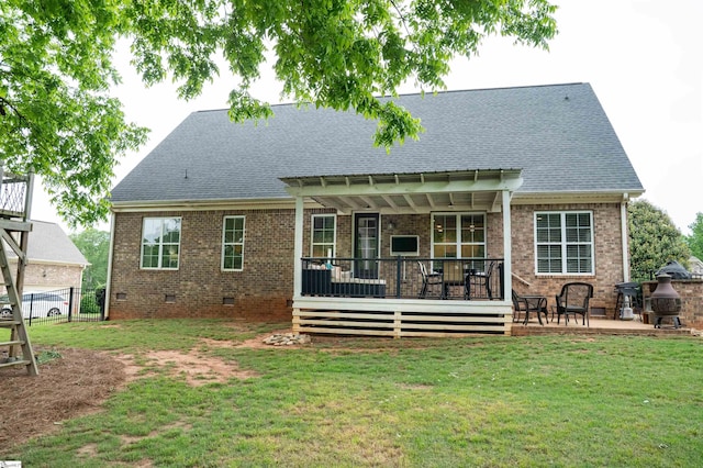 rear view of house with crawl space, brick siding, roof with shingles, a wooden deck, and a patio area