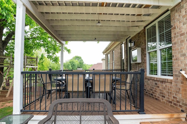 view of wooden balcony with outdoor dining area and a deck