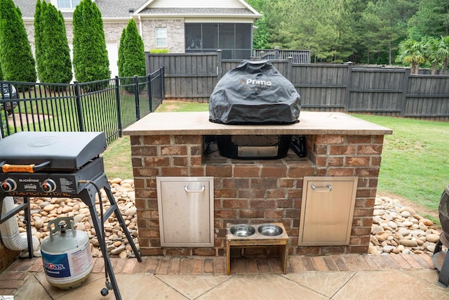 view of patio featuring area for grilling, a fenced backyard, and a sunroom
