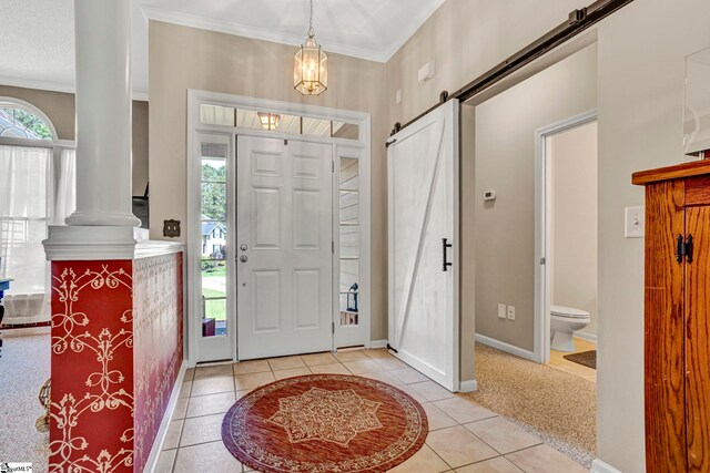 5 Laurelcrest Ln, Travelers Rest, SC 29690 - entrance foyer featuring ornate columns, a barn door, light tile patterned floors, crown molding, and baseboards