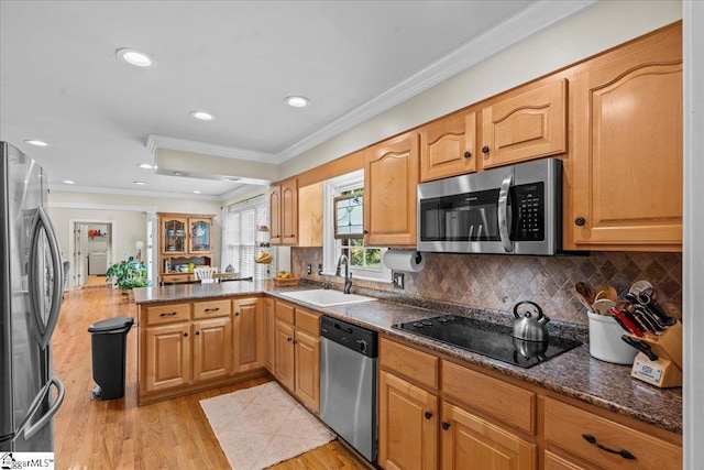 kitchen with stainless steel appliances, a sink, crown molding, a peninsula, and light wood-style floors
