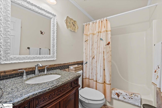 bathroom featuring toilet, ornamental molding, vanity, and shower / tub combo